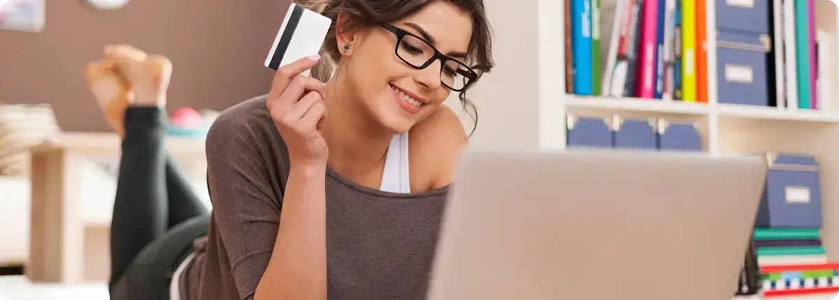 Mujer comprando gafas de eclipse solar Spectrum online usando un portátil.
